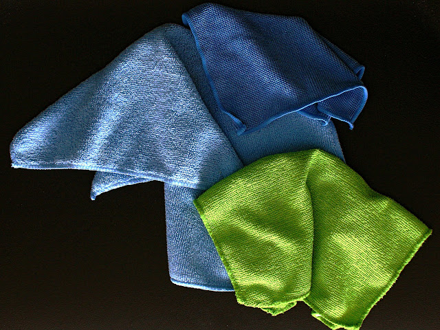 Dark blue, blue, and green microfiber towels on a black table