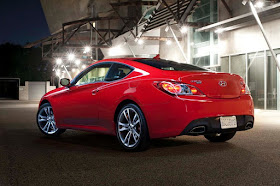 Rear 3/4 view of 2011 Hyundai Genesis Coupe 3.8 R-spec at night in front of a warehouse