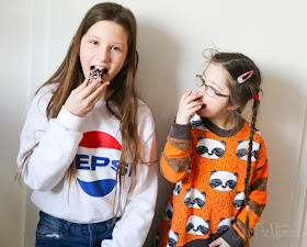 Louisa und Jolina essen einen bunten Schaumkuss