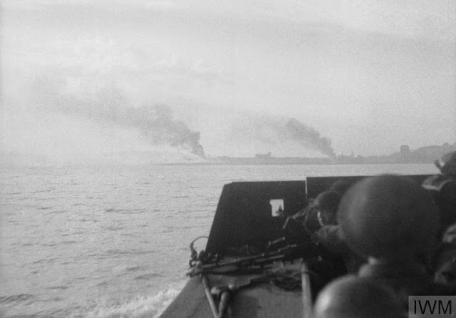 Dieppe shoreline viewed from a landing craft as it approached; fires are burning visibly in the hinterland as a result of the naval and aerial bombardment.