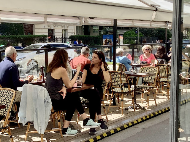 2 young women sitting in a cafe outdoors