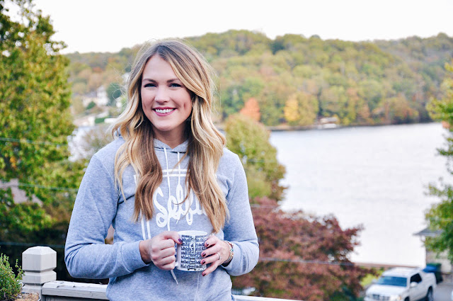 happy girl with mug of cider by the lake