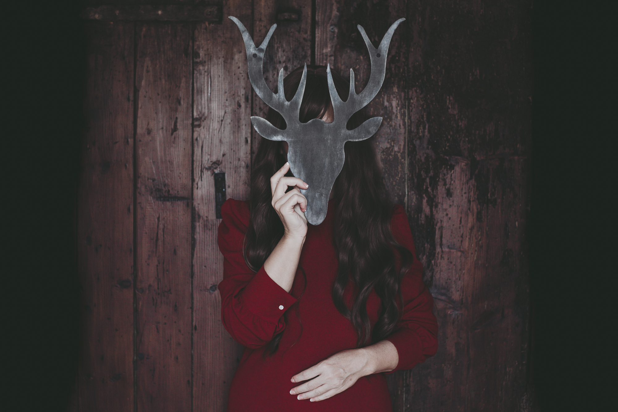 una donna vestita di rosso con una maschera di un cervo