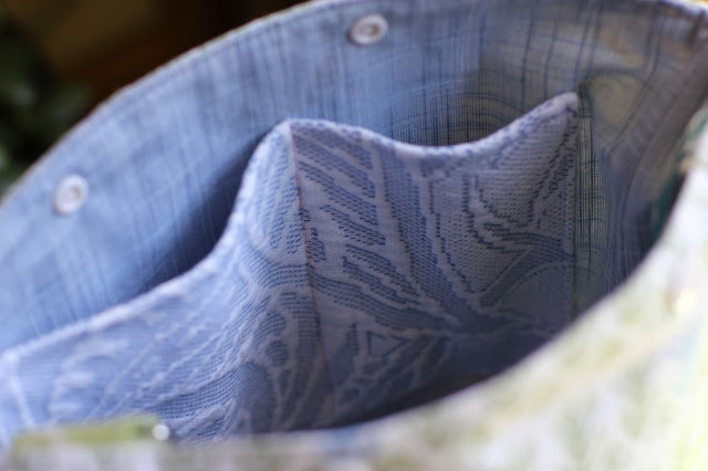 Close-up of blue and white floral dual pockets sewn into blue chambray lining of a project bag.