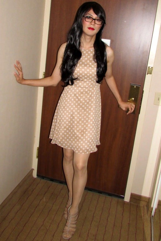 Pretty crossdresser wearing a cute dress with suntan pantyhose and heels