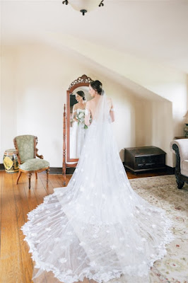 bride looking in mirror with lace wedding veil