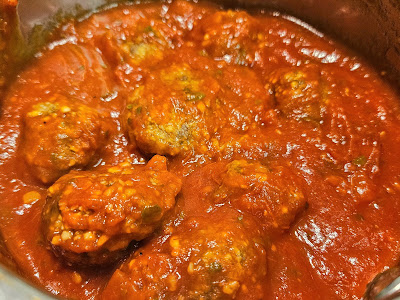 Cooked meatballs in spaghetti sauce.