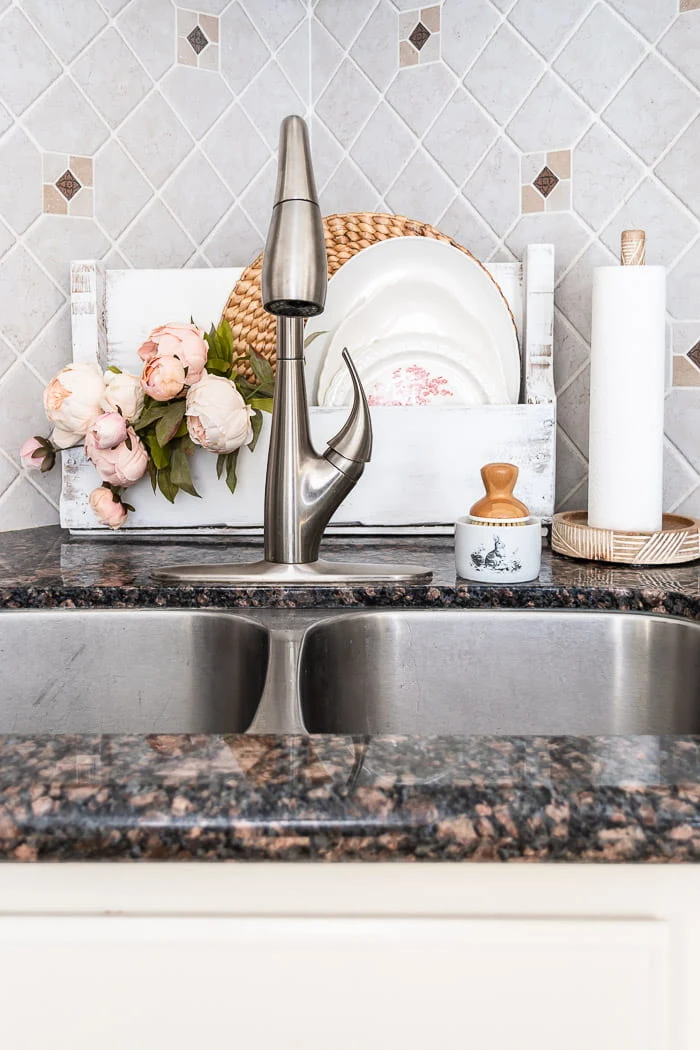 Spring wood tote, flowers and platters behind corner sink