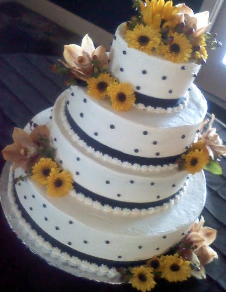 Four tier black and white polka dot cake with orchids yellow flowers and