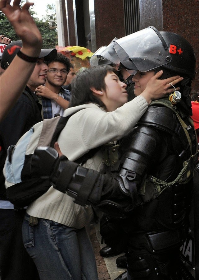35 moments of violence that brought out incredible human compassion - a student protesting education reform leans in to kiss a riot officer