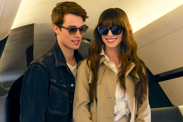 A woman and man board a plane together both wearing sunglasses