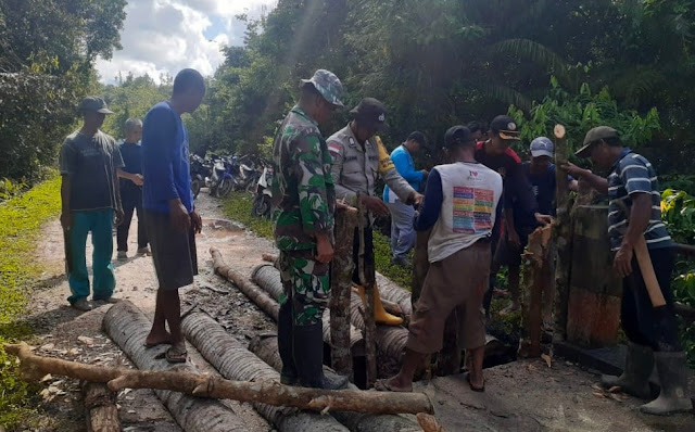 Babinsa Jesben Hutagalung Ikut Gotong Royong bersama Warga Memperbaiki Jembatan di Desa Tapau 