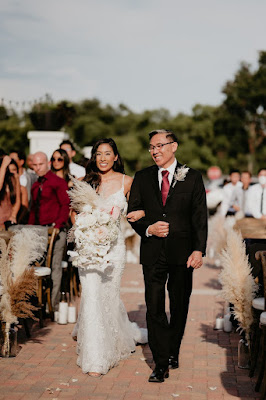 bride being escorted down the aisle with bridal bouquet