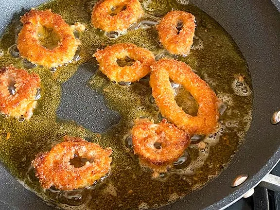 Shallow frying panko crumbed calamari.
