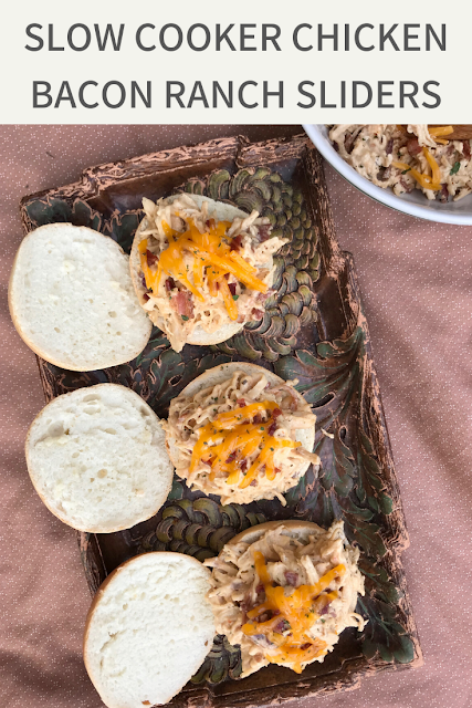Creamy ranch chicken is slow cooked and topped with bacon and cheese on slider sized rolls for a delicious family pleasing meal.