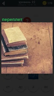 На полу лежат стопкой книги, у которых сделан новый переплет