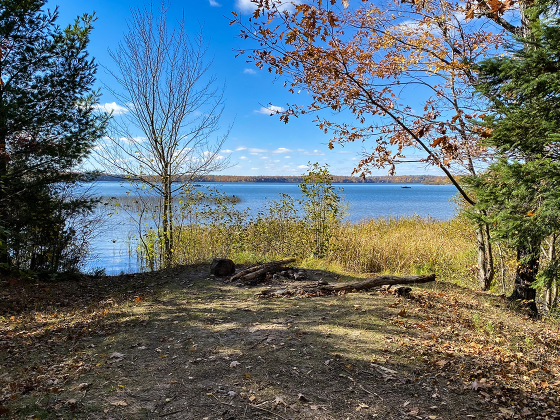 wind swept lake beyond peninsula with stone fire ring