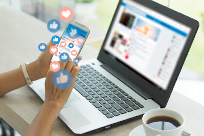 Digital Marketing work station with a computer, mobile phone and a white mug of beverage.