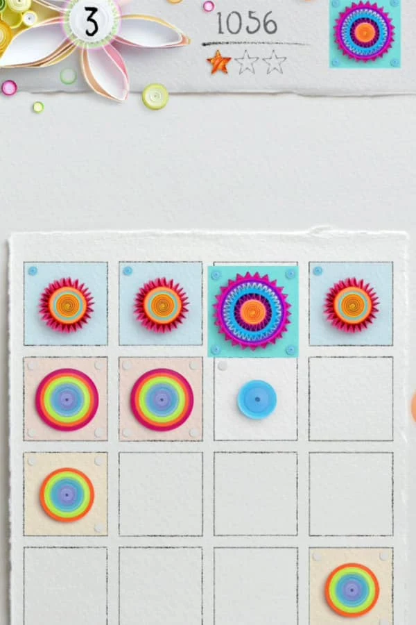 image of mobile game board shows colorful circular discs and floral on edge paper art