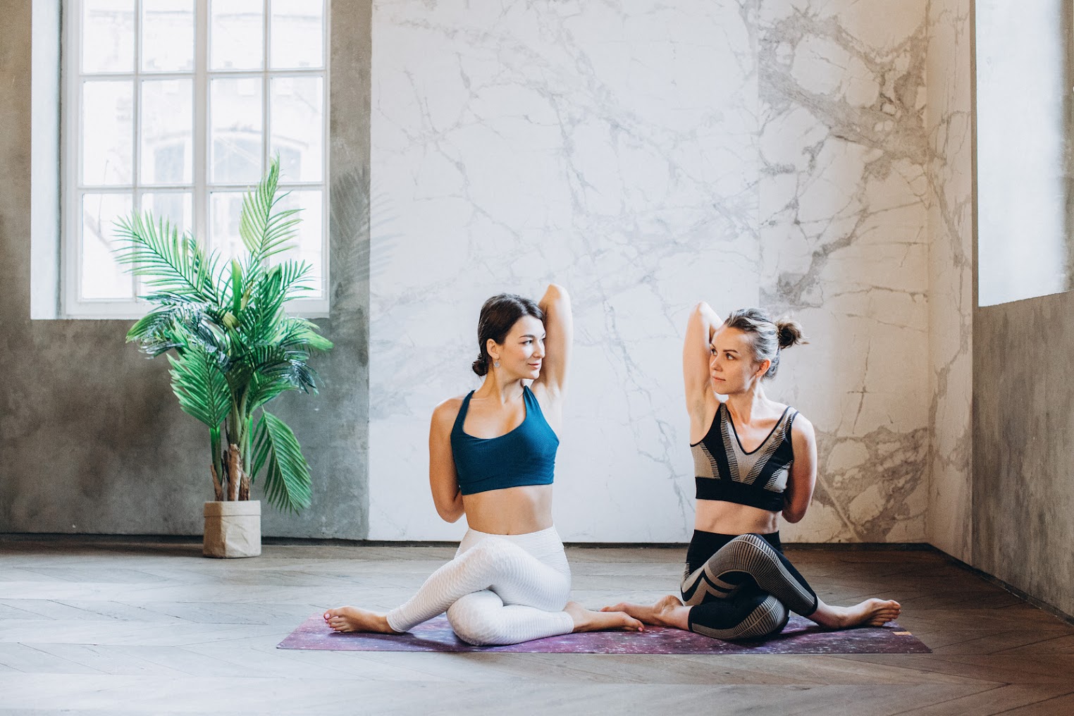 Two women in a Yoga pose facing each other