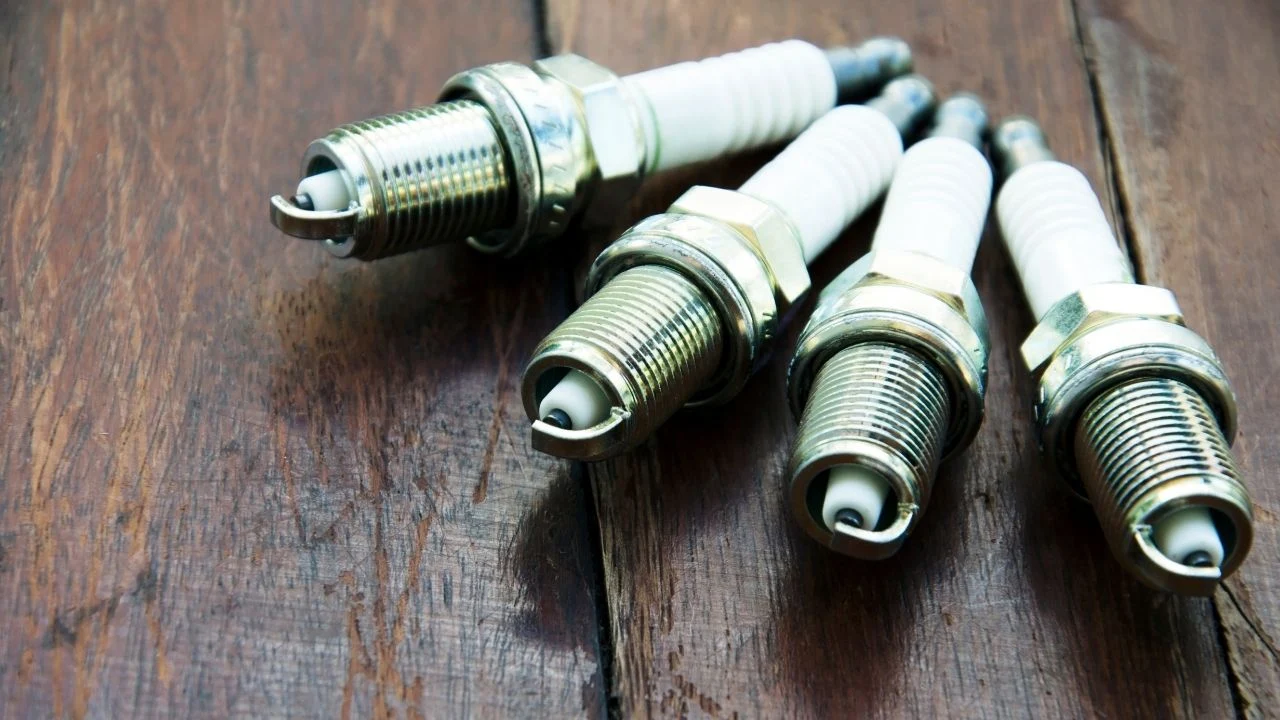 Spark plugs with a wooden floor background.
