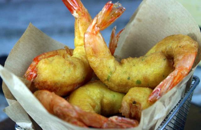 gambas fritas a la gabardina en papel absorbente recién sacadas de la freidora