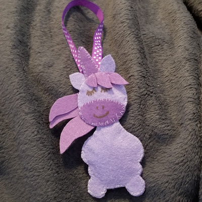 Purple felt unicorn decoration sewn together with white thread