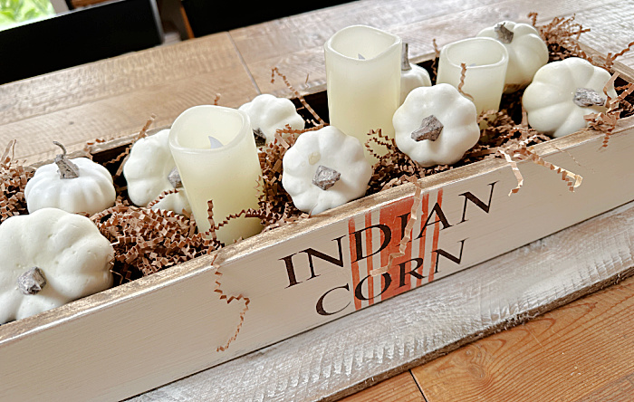 crate with small pumpkins and candles