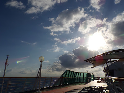 Sun through the clouds over the deck of a cruise ship