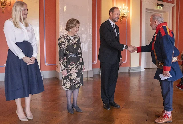 Crown Princess Mette-Marit wore a silk blouse and navy blue skirt. Queen Sonja wore a floral print midi dress