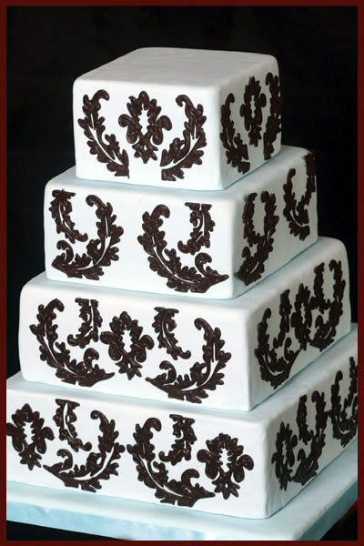 Elegant three tier square wedding cake with damask pattern and black satin