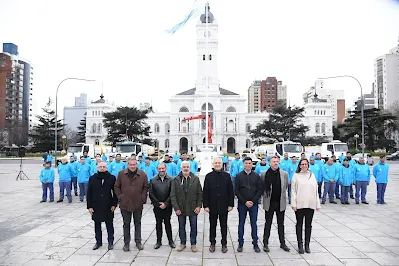 Programa Ciudad Limpia: Alak lidera la iniciativa de restauración urbana para espacios públicos Grupo de trabajadores en uniforme azul y mascarillas frente a edificio histórico con bandera argentina, participando en el Programa Ciudad Limpia liderado por Alak para restaurar espacios públicos vandalizados