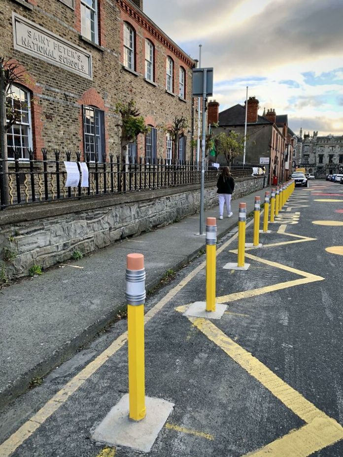 Not just boring road obstacles, but giant pencils separating the school grounds from the roadway.