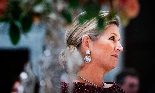 Maxima wore a ruby red embroidered cape by Jan Taminiau. Diamond earrings have been disassembled from Stuart diadem