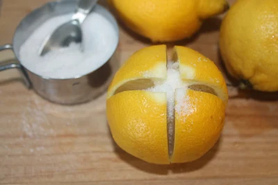 Cut lemons being stuffed with salt.