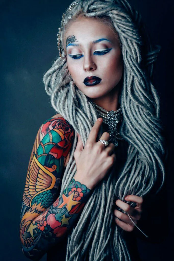 chica con el pelo de lana, lleva tatuaje de aguila a color en el brazo