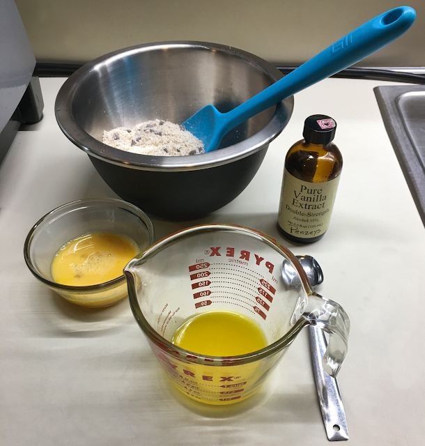 Cookie baking mix in bowl, next to the wet ingredients on countertop