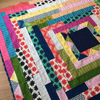 bright quilt, with square centre and jelly roll strips