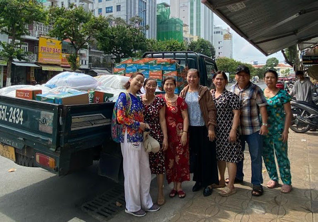 Thanh Mai Phan standing by a truck full of food supplies to distribute at the temple in Xã Tân Mỹ.