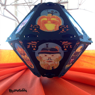 View of the pumpkin and scarecrow on vintage-style Bindlegrim Halloween paper lantern floating over a sea of vintage orange crepe. 