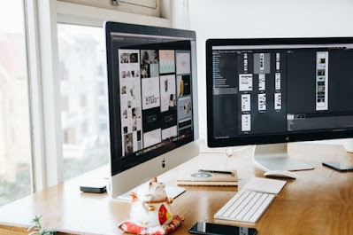 silver iMac on top of brown wooden table