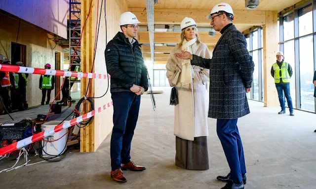 Queen Maxima wore a handmade melange wool coat by Massimo Dutti, and white blouse and wide leg pants by Natan. Susan Gail bag