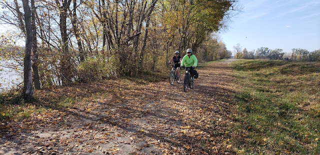 Two women riding bicycles on the trail alongside the Missouri River.