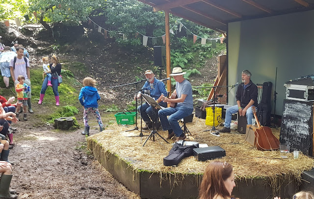 The Workshy Fops band performing 3 musicians singing playing cajon and 2 guitars woodland stage Just So Festival 2019 