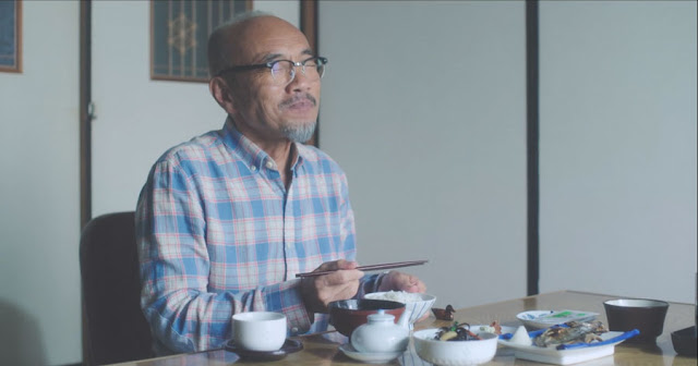 Vemos al protagonista Takeshi Kasumi (Naoto Takenaka) feliz comiendo arroz, lleva una camisa de cuadros