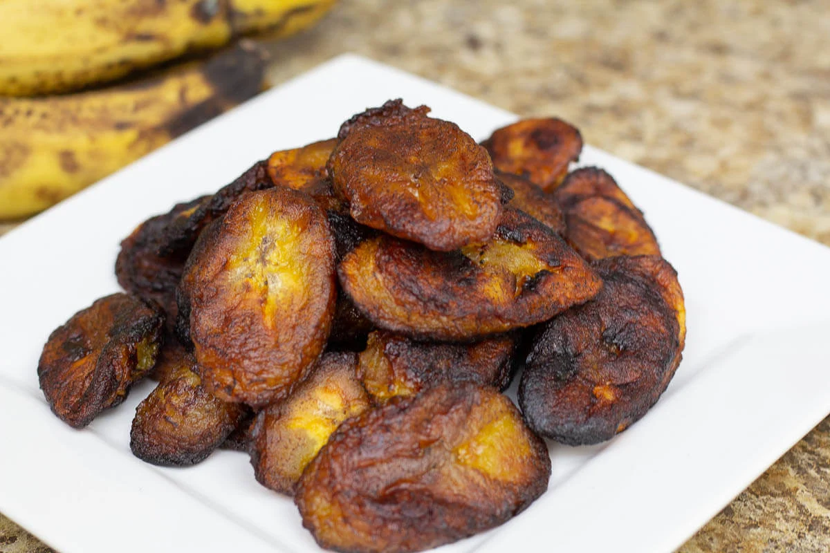 A group of pan fried plantains on a white plate.