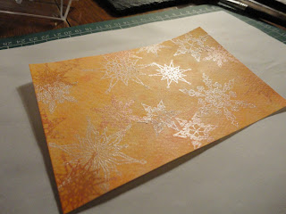 Orange salt background with snowflakes in ink and white mica powder