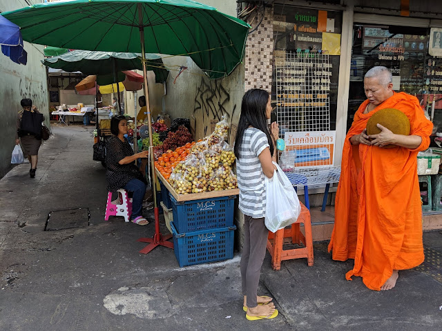 A young woman prays with a Buddhist monk in Bangkok, Thailand