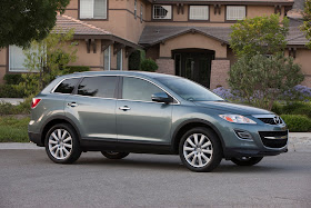 Front 3/4 view of silver 2011 Mazda CX-9 parked in front of home