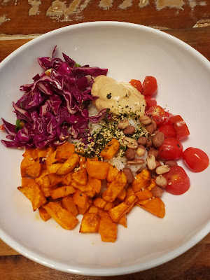 donburi bowl of rice, sweet potatoes, cabbage slaw, cherry tomatoes, and sauce